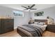Neutral bedroom features a ceiling fan, a comfortable bed, and a dresser for clothing storage at 5200 Dove Dr, New Port Richey, FL 34652