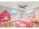 Charming pink bedroom with a decorative bookshelf and bright natural light at 5200 Dove Dr, New Port Richey, FL 34652