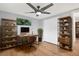 Industrial-style home office features a desk, bookshelves, a ceiling fan, and modern decor at 5200 Dove Dr, New Port Richey, FL 34652