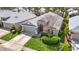 Aerial view of a well-maintained home featuring a manicured lawn, two-car garage, and lush landscaping at 5351 Lookout Pass, Wesley Chapel, FL 33544