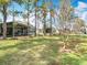 Spacious backyard with lush green grass, mature trees and views of neighboring homes at 5351 Lookout Pass, Wesley Chapel, FL 33544