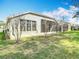 View of backyard and screened-in porch of home under a sunny, partly cloudy sky at 5351 Lookout Pass, Wesley Chapel, FL 33544