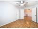 A bright bedroom featuring wood-look floors, ceiling fan, and access to the dining area at 5351 Lookout Pass, Wesley Chapel, FL 33544