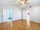 A bright bedroom featuring wood-look floors, ceiling fan, and access to the bathroom and kitchen at 5351 Lookout Pass, Wesley Chapel, FL 33544