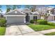 Charming gray one-story home with a well-manicured lawn and an attached garage at 5351 Lookout Pass, Wesley Chapel, FL 33544