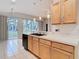 Well-lit kitchen with wooden cabinetry, stainless sink, and white countertop at 5351 Lookout Pass, Wesley Chapel, FL 33544