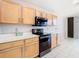 Bright kitchen featuring natural wood cabinetry and stainless steel appliances at 5351 Lookout Pass, Wesley Chapel, FL 33544