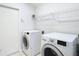 Laundry room featuring white washer and dryer, tile floors and wire shelving at 5351 Lookout Pass, Wesley Chapel, FL 33544