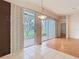 Bright living room with large windows and sliding doors to a screened lanai; wood and tile floors at 5351 Lookout Pass, Wesley Chapel, FL 33544
