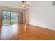 Open living room with hardwood floors, ceiling fan, and sliding glass doors to the outside patio at 5351 Lookout Pass, Wesley Chapel, FL 33544