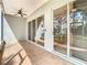 Covered patio with tile flooring, ceiling fan, and large sliding glass doors at 5351 Lookout Pass, Wesley Chapel, FL 33544