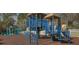 Outdoor playground with blue climbing structure, swings, and slides, surrounded by a white fence at 5351 Lookout Pass, Wesley Chapel, FL 33544