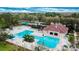 Aerial view of community pool featuring a sun deck, playground, and clubhouse perfect for Gathering activities at 5351 Lookout Pass, Wesley Chapel, FL 33544