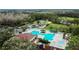 Aerial view of community pool, playground, basketball court, parking, and common areas surrounded by lush landscaping at 5351 Lookout Pass, Wesley Chapel, FL 33544
