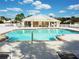 Community pool featuring a covered seating area with tables, chairs, and lounge chairs for relaxing poolside at 5351 Lookout Pass, Wesley Chapel, FL 33544