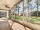 Large screened porch with tile flooring and ceiling fan overlooking a spacious backyard at 5351 Lookout Pass, Wesley Chapel, FL 33544