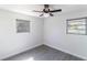 Bright bedroom with two windows, modern ceiling fan, light gray flooring and white walls at 5406 S 87Th St, Tampa, FL 33619