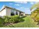 Lush backyard with a well-maintained lawn, beautiful landscaping, and partial fence at 5647 Del Coronado Dr, Apollo Beach, FL 33572
