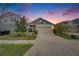 Inviting home at dusk with a well-kept lawn, a two-car garage, and lush landscaping at 5647 Del Coronado Dr, Apollo Beach, FL 33572
