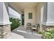 Inviting front porch with comfortable seating, stone accents, and a charming green front door at 5647 Del Coronado Dr, Apollo Beach, FL 33572