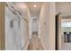 Hallway with wood floors, modern art, and stainless steel refrigerator at 5647 Del Coronado Dr, Apollo Beach, FL 33572