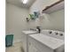 Bright laundry room features washer, dryer, and storage shelves at 5647 Del Coronado Dr, Apollo Beach, FL 33572