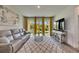 Comfortable living room with a large sofa, and backyard views through glass doors at 5647 Del Coronado Dr, Apollo Beach, FL 33572