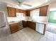 Traditional style kitchen with tile backsplash, wood cabinets, stainless steel appliances, and tile flooring at 6926 Echo Lake Dr, New Port Richey, FL 34653