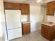 Open kitchen with white appliances, tile flooring, and natural wood cabinetry at 6926 Echo Lake Dr, New Port Richey, FL 34653