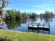 Picturesque lake view with a private dock, surrounded by lush greenery at 6926 Echo Lake Dr, New Port Richey, FL 34653