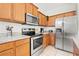 Close-up view of a kitchen featuring stainless steel appliances, granite countertops, and warm wood cabinetry at 707 Fern Leaf Dr, Ruskin, FL 33570