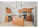 Well-equipped kitchen with granite countertops, stainless steel appliances, wood cabinetry, and a functional center island at 707 Fern Leaf Dr, Ruskin, FL 33570