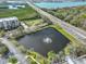 Nice aerial view of a pond with a fountain next to a building and an overpass with road traffic at 7194 Key Haven Rd # 405, Seminole, FL 33777