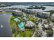 Stunning aerial shot of condos, tennis courts, and a pool with palm trees, offering a resort-style atmosphere at 7194 Key Haven Rd # 405, Seminole, FL 33777