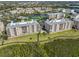 An aerial view of the condominiums from behind the back of the units. Lush green landscape at 7194 Key Haven Rd # 405, Seminole, FL 33777