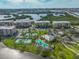 Beautiful aerial view of condos, tennis courts, and swimming pool surrounded by lush landscaping and water at 7194 Key Haven Rd # 405, Seminole, FL 33777