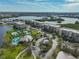 An aerial view of condominiums with two tennis courts and a turquoise pool surrounded by manicured landscaping at 7194 Key Haven Rd # 405, Seminole, FL 33777