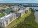 Aerial view of lakeside condos with tennis courts and a pool showcasing a vibrant waterfront community at 7194 Key Haven Rd # 405, Seminole, FL 33777