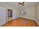 A serene bedroom with hardwood floors, a window, neutral walls, a ceiling fan, and an open doorway at 7194 Key Haven Rd # 405, Seminole, FL 33777