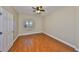 A serene bedroom with hardwood floors, a window, neutral walls, and a ceiling fan at 7194 Key Haven Rd # 405, Seminole, FL 33777