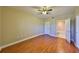 A serene bedroom with hardwood floors, neutral walls, a ceiling fan, and an ensuite bathroom at 7194 Key Haven Rd # 405, Seminole, FL 33777