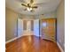 Neutral-toned bedroom featuring hardwood floors, ceiling fan, and natural light at 7194 Key Haven Rd # 405, Seminole, FL 33777