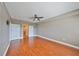 Spacious bedroom featuring hardwood floors, ceiling fan, and double-door closets at 7194 Key Haven Rd # 405, Seminole, FL 33777