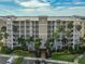 Exterior of condo building featuring multiple floors, balconies, manicured landscaping, and ample parking at 7194 Key Haven Rd # 405, Seminole, FL 33777