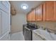 Well-equipped laundry room with modern washer and dryer, sink and ample cabinet space at 7194 Key Haven Rd # 405, Seminole, FL 33777