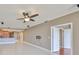 Open-concept living room with tile flooring, a ceiling fan, and access to the kitchen and bedrooms at 7194 Key Haven Rd # 405, Seminole, FL 33777