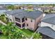 Aerial view of a two-story home featuring manicured backyard, screened-in lanai, patio space and palm trees at 7414 S Kissimmee St, Tampa, FL 33616