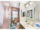 Dual view of bathroom with shower and vanity areas; updated features and ample lighting create inviting spaces at 799 Fairwood Ln, Clearwater, FL 33759