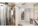 Hallway with stairs and a stainless steel refrigerator with white bi-fold doors at 799 Fairwood Ln, Clearwater, FL 33759
