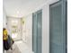 Hallway with white tile floors, a glass-paneled door, and blue closet doors at 799 Fairwood Ln, Clearwater, FL 33759